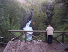 An image of a woman looking at the waterfall of the Siete Tasas (Radal), Chile.